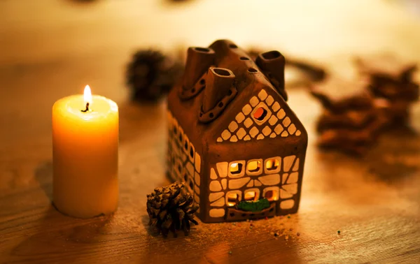 Fee Kerst huis taart met kaarslicht binnen en mooie achtergrondverlichting — Stockfoto