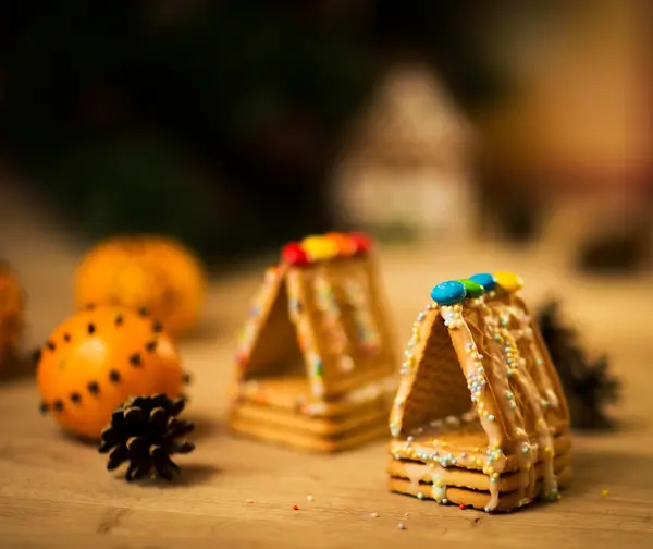 Schönes Lebkuchenhaus auf Holzgrund mit Weihnachtsdekoration — Stockfoto