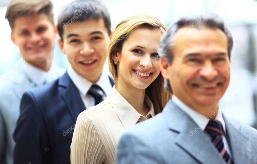 Happy smiling business team standing in a row at office