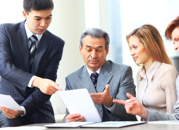 Squadra commerciale seria con i calcolatori del pc della compressa, documenti che hanno discussione nell'ufficio — Foto Stock