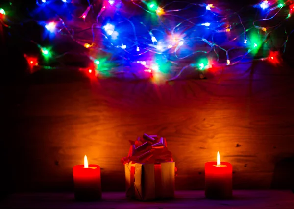 Bellissimo sfondo in legno per etichette con luci di Natale regalo e con candele — Foto Stock