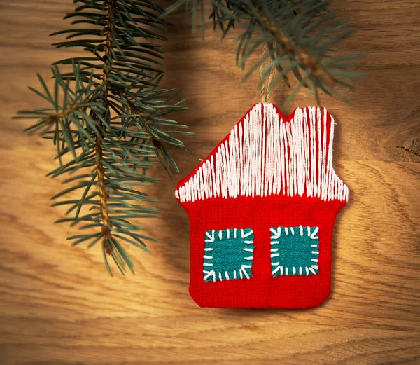Beautiful Christmas house with fir paws on wooden background — Stock Photo, Image