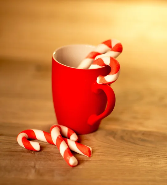 Mug Of Tea Or Coffee. Sweets. Christmas Decorations. Red Balls And Bells. Wooden Background — Stock Photo, Image