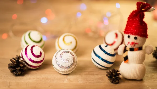 Mooie sneeuwpop met kerstballen en mooie verlichting op houten achtergrond — Stockfoto
