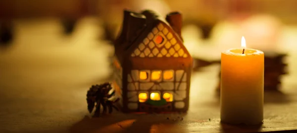 Fee Kerst huis taart met kaarslicht binnen en mooie achtergrondverlichting — Stockfoto