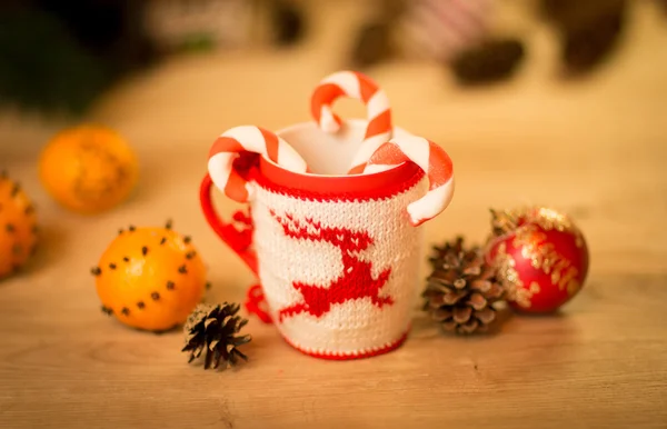 Insulated wool cloth mug with embroidered deer on the wooden table mug with tangerines and a candy — Stock Photo, Image