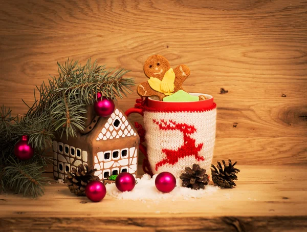 Egy bögre teát vagy kávét. Ajándék piros szalaggal és. Édességek és fűszerek. Karácsonyi dekoráció. Fa háttér — Stock Fotó