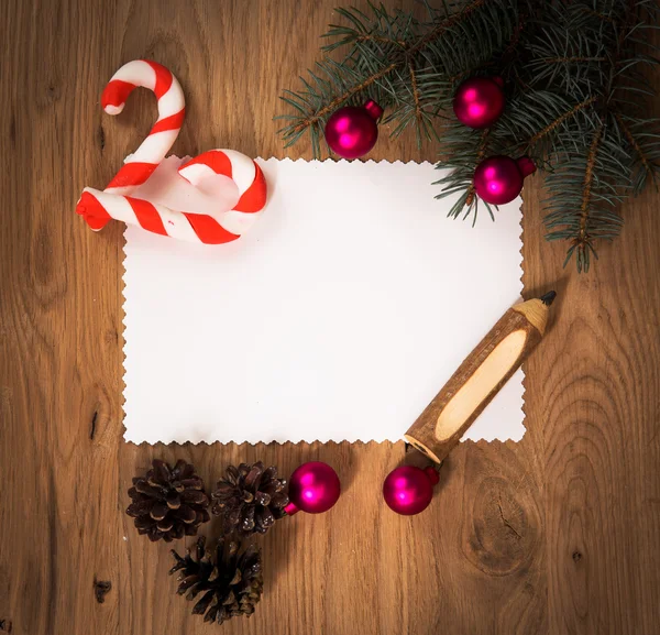 Hoja de papel en blanco en el suelo de madera con un lápiz y decoraciones de Navidad —  Fotos de Stock