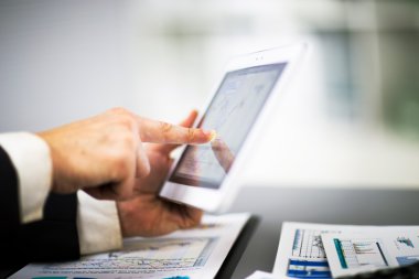 Dijital tabletin ekranına dokunan bir iş adamı
