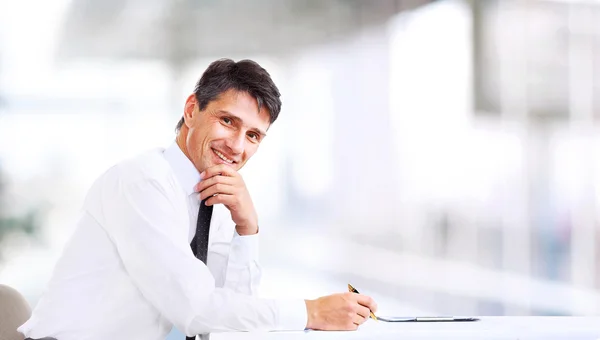 Przystojny biznesmen uśmiechający się do biura — Zdjęcie stockowe