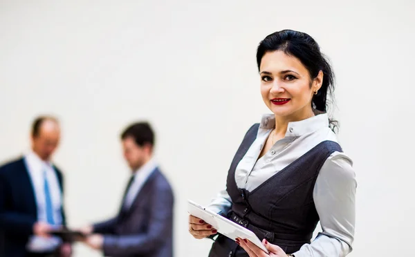 Modern affärskvinna hålla tablet PC med kollega på bakgrund — Stockfoto