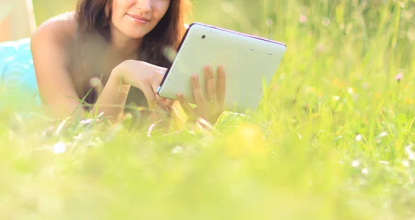 Glad kvinna läser e-bok i parken — Stockfoto
