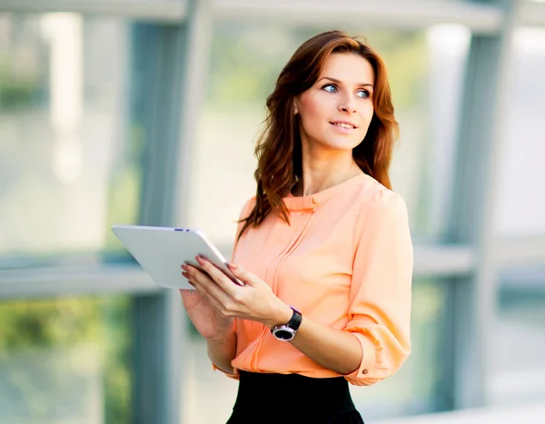 Młoda kobieta biznesu uśmiechający się trzymając komputer cyfrowy tablicowy — Zdjęcie stockowe