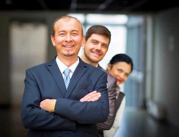 Employés souriants debout autour de leur gestionnaire — Photo