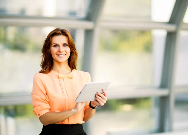 Joven mujer de negocios sonriente sosteniendo tableta digital — Foto de Stock