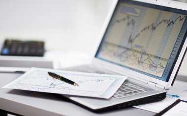 dizüstü bilgisayar ile yatırım grafikleri analiz bir iş adamı. muhasebe