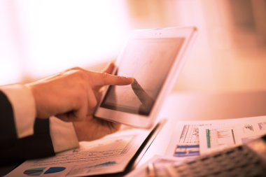 Dijital tabletin ekranına dokunan bir iş adamı
