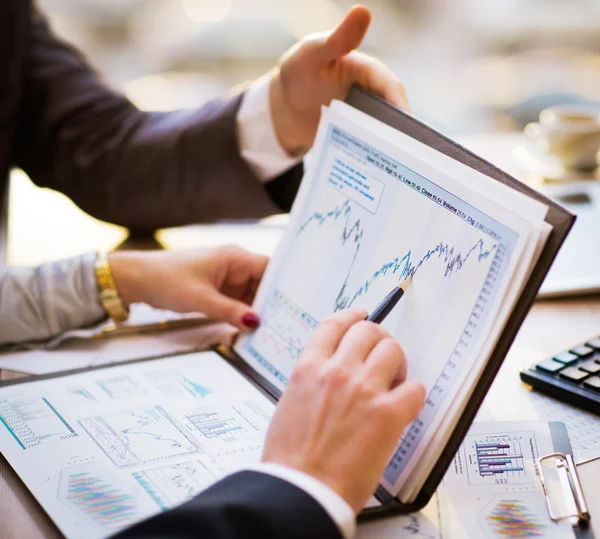 Close-up van vrouwelijke en mannelijke handen wijzend op bedrijfsdocument tijdens de bespreking van het — Stockfoto