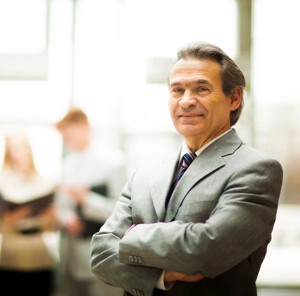 Feliz hombre de negocios inteligente con compañeros de equipo discutiendo en segundo plano —  Fotos de Stock