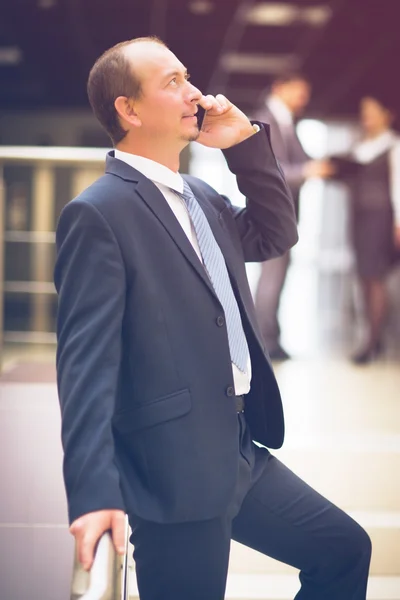 Homem de negócios falando no telefone celular no escritório moderno — Fotografia de Stock