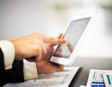 Dijital tabletin ekranına dokunan bir iş adamı