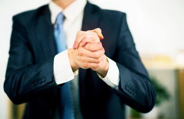 Üzletember, az irodában, a kezével hajtva. Szándékát, hogy a barátság és együttműködés. Stock Fotó