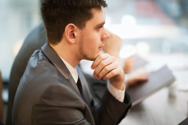 Homme d'affaires occasionnel penser avec l'équipe derrière lui dans le bureau — Photo