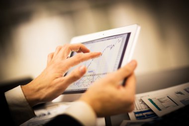 Dijital tabletin ekranına dokunan bir iş adamı