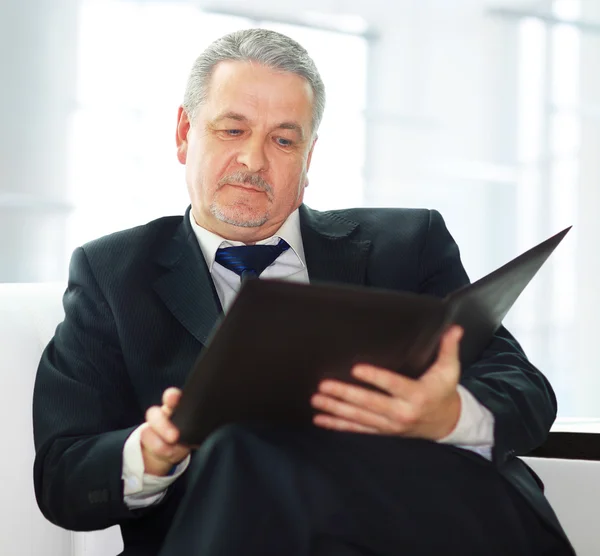 Hombre de negocios guapo sentado en el sofá de la oficina — Foto de Stock