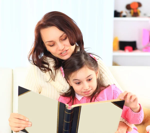 Lycklig mor och dotter läser en bok tillsammans — Stockfoto