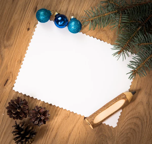Feuille de papier vierge sur le sol en bois avec un crayon et des décorations de Noël — Photo