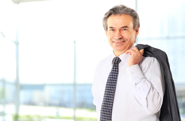 Fröhlicher Geschäftsmann mit verschränkten Armen, der in die Kamera blickt — Stockfoto