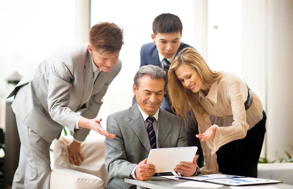 Seriöses Business-Team mit Tablet-Computern, Dokumenten, die im Büro diskutiert werden — Stockfoto