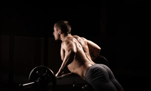 Sehr kraftvoller, athletischer Typ, führt Übungen mit Hanteln in der Sporthalle aus — Stockfoto