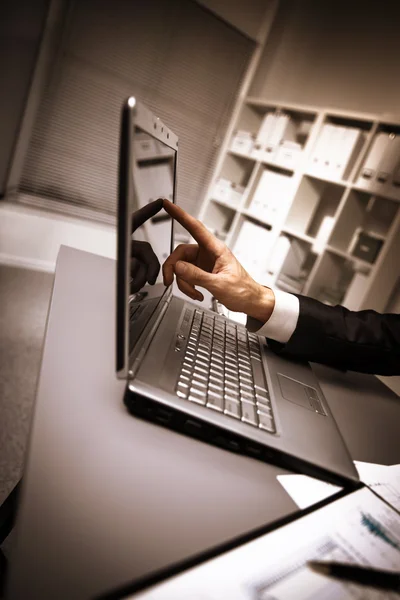 Pessoa digitando em um laptop moderno em um escritório — Fotografia de Stock