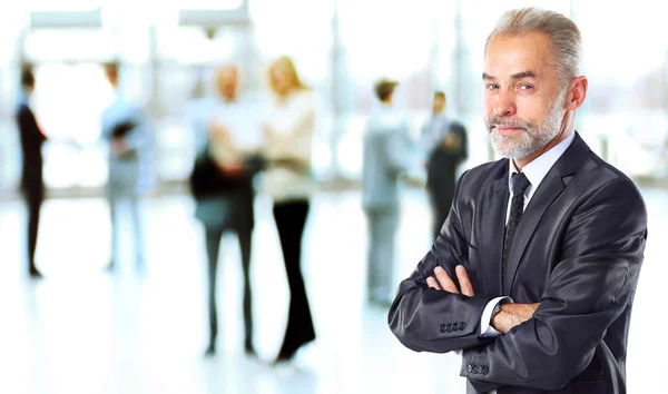 Feliz hombre de negocios inteligente con compañeros de equipo discutiendo en segundo plano — Foto de Stock