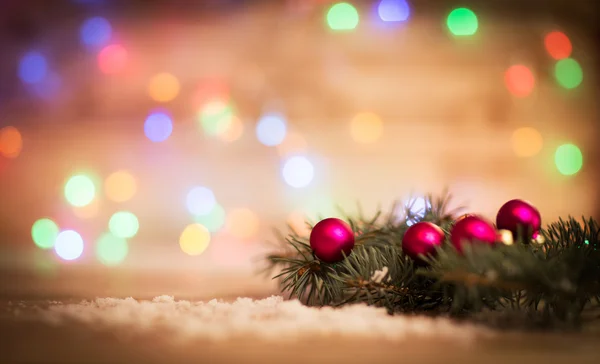 Gros plan d'une boule de Noël rouge et branches de sapin sur fond de bois . — Photo