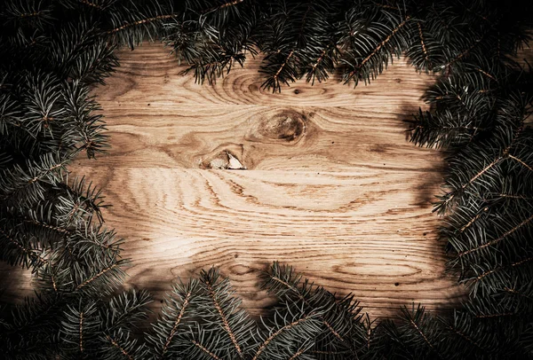 Branches de sapin vert sur le sol en bois avec assombrissement sur les bords — Photo