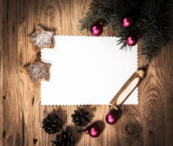 Hoja de papel en blanco en el suelo de madera con un lápiz y decoraciones de Navidad —  Fotos de Stock