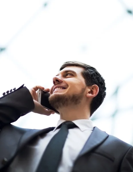 Young business man talking on cell phone at modern office — Stock Photo, Image