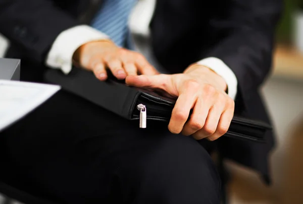 Selbstbewusster Geschäftsmann mit einem Ordner in der Hand im Büro — Stockfoto