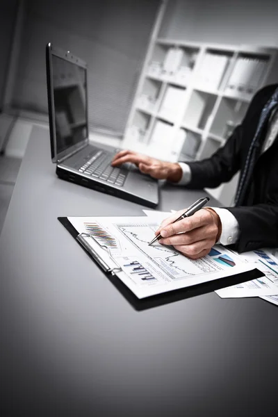 Närbild på manliga händer göra pappersarbete med penna och laptop. — Stockfoto
