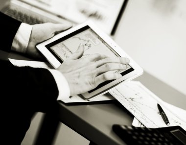Dijital tabletin ekranına dokunan bir iş adamı