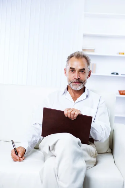 En respektabel affärsman, en man i ålder, på kontoret, sitter — Stockfoto