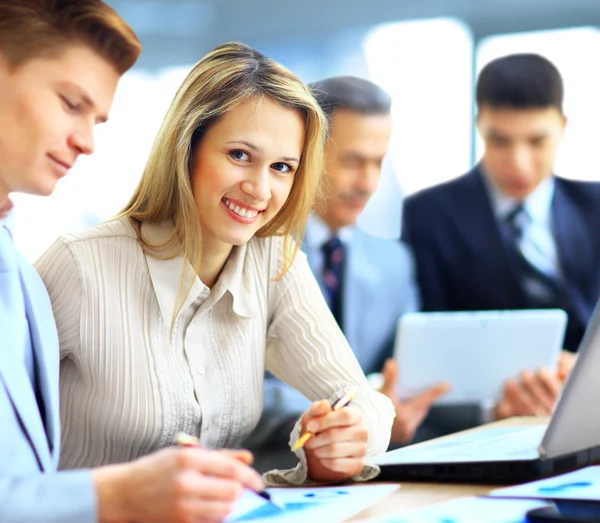 Sorrindo empresária posando enquanto colegas conversando juntos no escritório brilhante — Fotografia de Stock