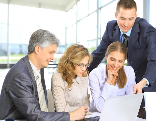 Gente de negocios sentada en una reunión corporativa trabajando en laptop Imágenes de stock libres de derechos