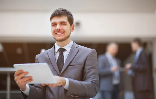 Jovem empresário com um tablet pc, no escritório — Fotografia de Stock