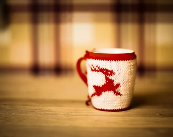 insulated wool cloth mug with embroidered deer on the wooden table