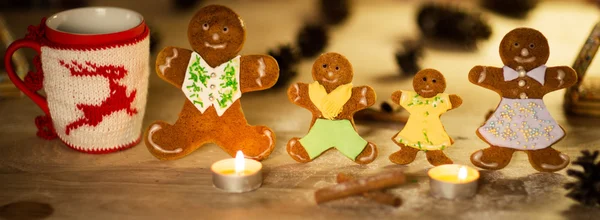 Candele di Natale uomini di pan di zenzero con stelle di cannella Pino ramoscello palla di Natale su un pavimento di legno — Foto Stock