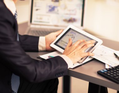 Dijital tabletin ekranına dokunan bir iş adamı